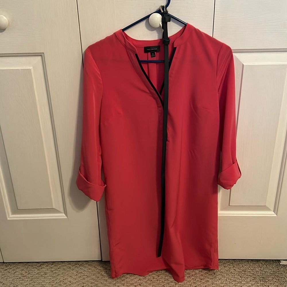 Shirt dress in pink with navy lining and navy belt. The sleeves are cuffed.